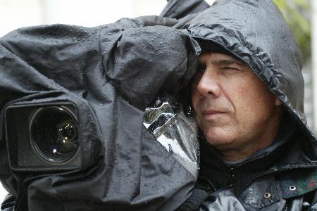 图文：一位摄像记者冒着大雨在急诊大楼外拍摄