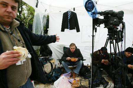 图文：守候的以色列电视台记者在风雨中吃快餐