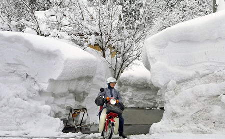 图文:日本邮递员从积雪前驶过