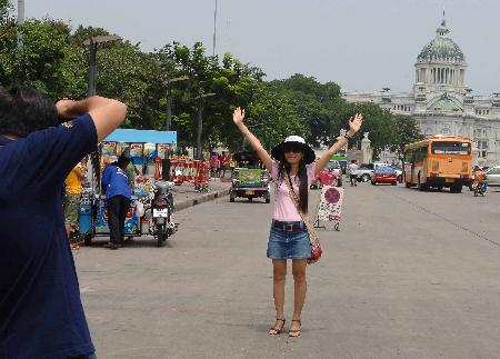 图文:市民在泰国首都曼谷的铜马广场前留影