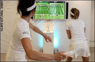 Two people playing tennis using the console
