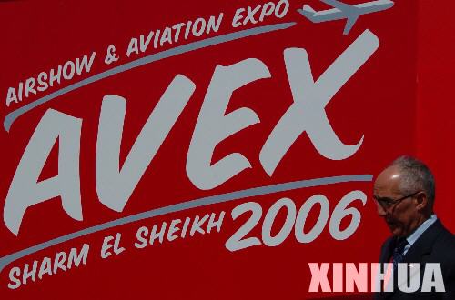 图文：参观者从埃及国际航空展的宣传画前走过