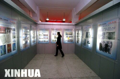 图文：工作人员经过基地展览馆历史图片展区