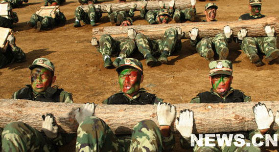 图文:队员们抱着圆木做仰卧起坐