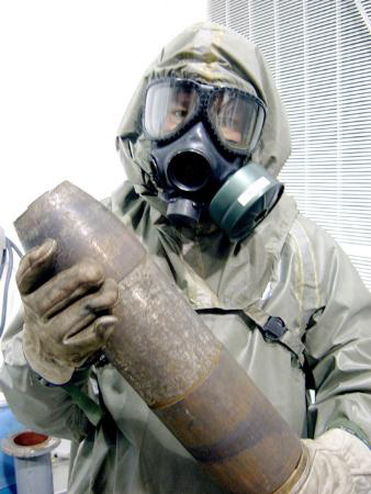 图文:工作人员手拿美国155毫米沙林毒气榴弹