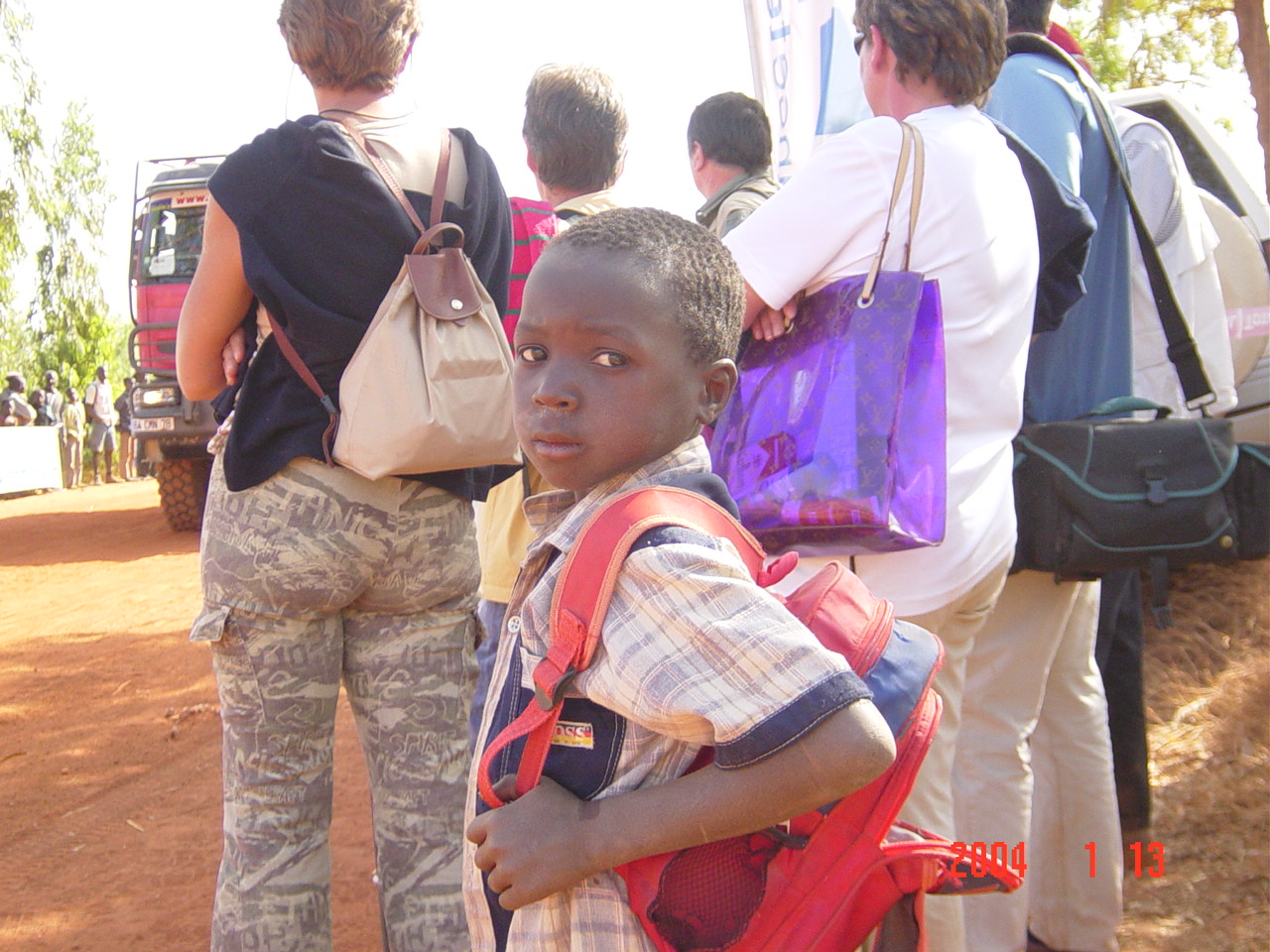 图文-达喀尔拉力赛第12日 非洲儿童背着书包看