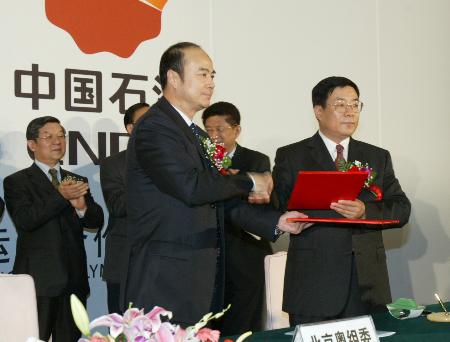 与中国石油天然气集团公司副总经理段文德在签约仪式上交换签字协议