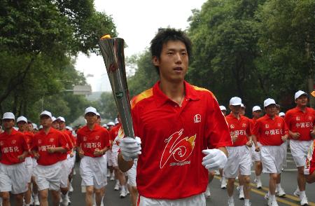 图文十运会火炬开始在成都传递顾俊杰手举火炬