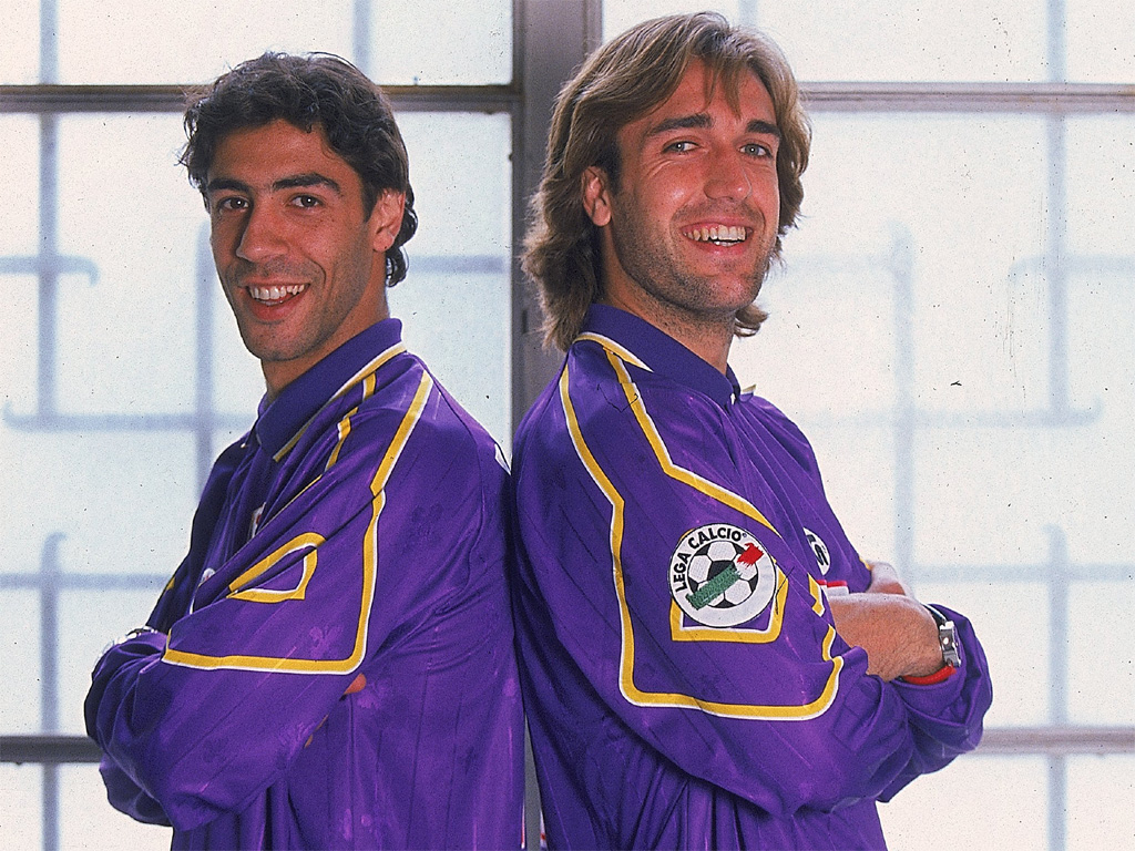  Rui Costa and Gabriel Batistuta, two of the greatest players to ever play for Fiorentina, stand together in their iconic purple jerseys.