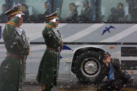 图文:武警战士在雪中向人大代表车队敬礼