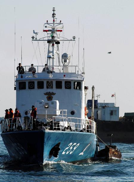 12月14日,一艘韓國海軍軍艦將一艘截獲的小型朝鮮鐵船(右)拖至韓國