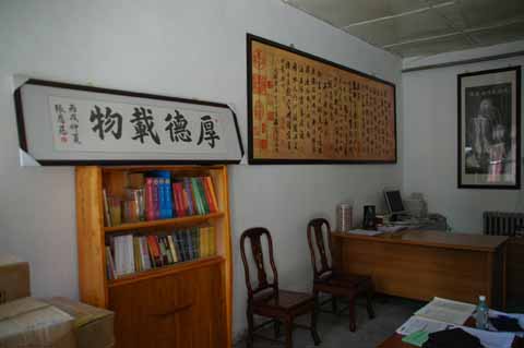 校长办公室悬挂着孔子的画像(右)