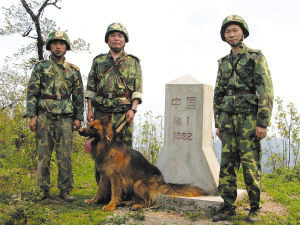 记者(右一)与巡逻官兵(中为团长林芝培)在中老边境一号界碑前留影