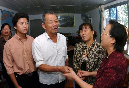 县委书记吴三八(右)代表当地党委政府来到陈文光家慰问(10月9日摄)