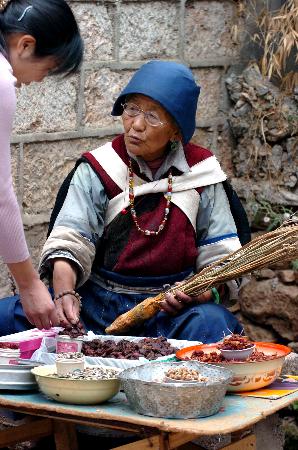 雪山腳下的束河古鎮6月20日,納西族老人木燦秀在束河古鎮賣土特產品