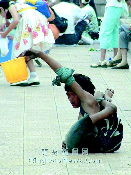 这是在青岛市街头拍到的残疾乞讨儿要钱的镜头本报记者臧磊摄