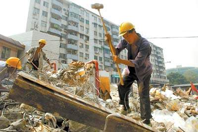 工人揮動大錘,對中大布匹市場的違章建築進行強制拆除.周馨攝