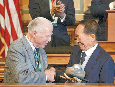 (左)在世界粮食奖颁奖仪式上与获奖的中国水稻专家袁隆平握手致意