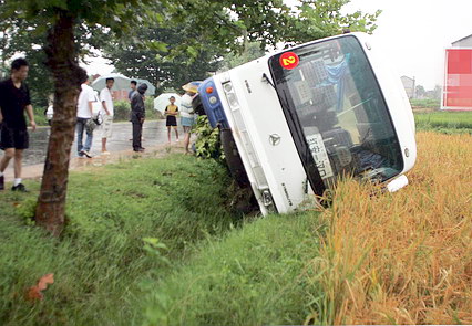 雨天路滑 一辆大客车侧翻入稻田(图)