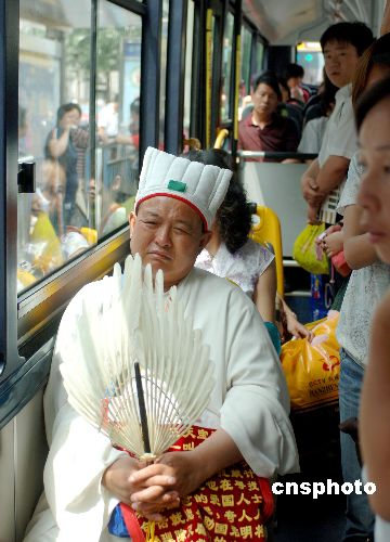 图:白衣道士不惧暑热乘坐北京公交车