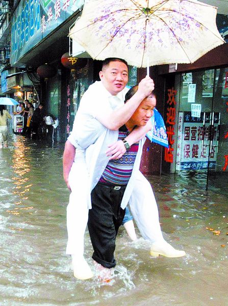 【江城暴雨即景之二】雨中"背人过街"生意还真不错(图)