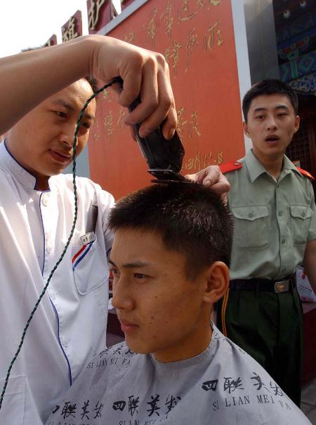 28日,北京王府井四联美发美容中心的理发师给天安门国旗班的战士理发