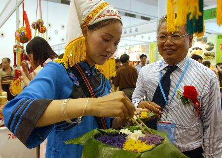 粮农产品绿色食品展览会暨农加工技术设备展示会上,一位壮族姑娘邀请