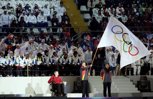 圖文都靈冬奧會閉幕式羅格手舉五環旗