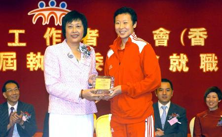 前右)接受原女排国手,中国体育工作者联会名誉会长陈亚琼(前左)赠送的